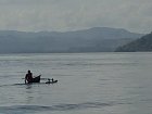 domorody rybar padluje katamaran mezi ostrovy